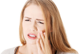 woman holding face having toothache in Fairfield, CA